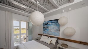 A bedroom with a bed, bedside table, and a painting. - Argana Naxos private villa with pool and garden (Plaka)