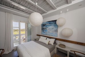 A bedroom with a bed, bedside table, and a painting.