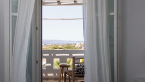 A balcony with a view of the landscape, a wooden chair, and a bed. - Argana Naxos private villa with pool and garden (Plaka)