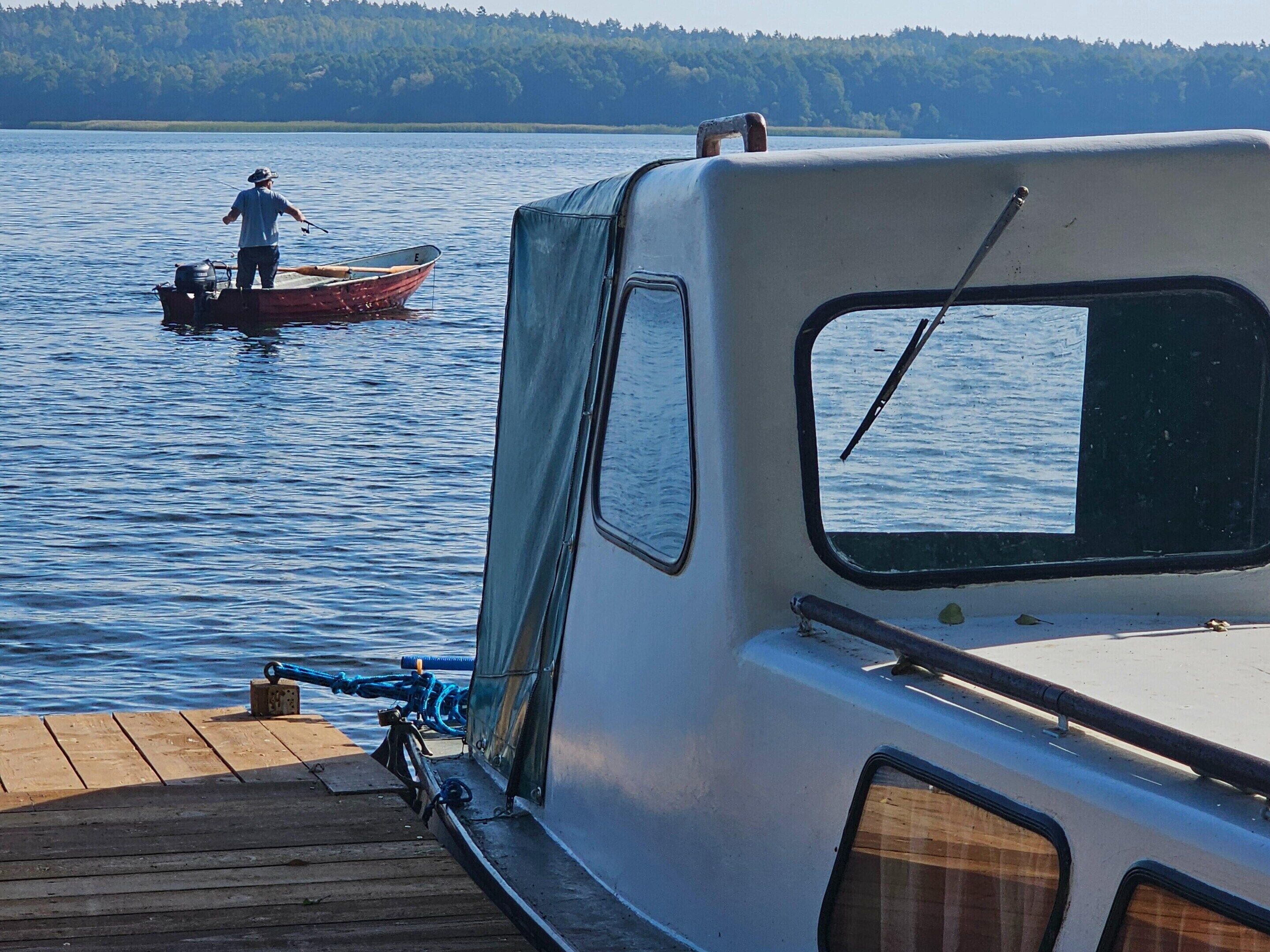 Un bateau était amarré à un quai, et une personne était en train de pêcher.