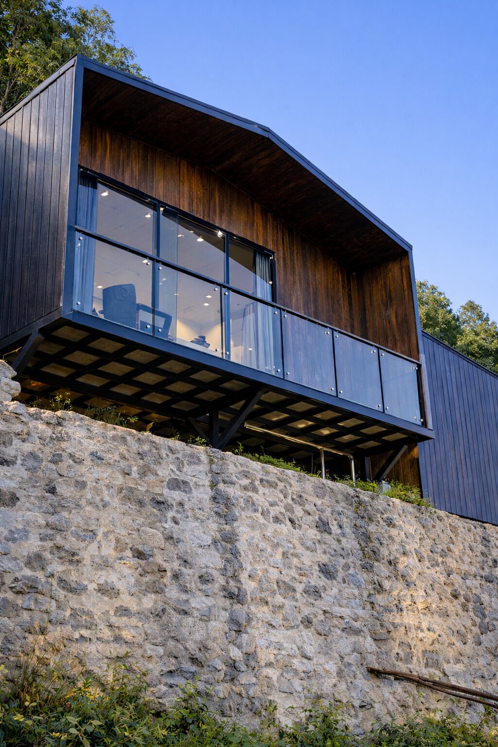 A modern building with a wooden facade, large windows, and a stone base.
