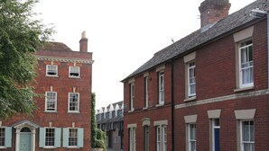 A quiet street lined with red brick buildings, featuring traditional architecture with symmetrical windows and doors. - The Townhouse (Salisbury)