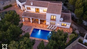 A two-story house with a swimming pool, surrounded by trees and a stone patio. - Villa HARMONIA by Abahana Villas (Teulada)