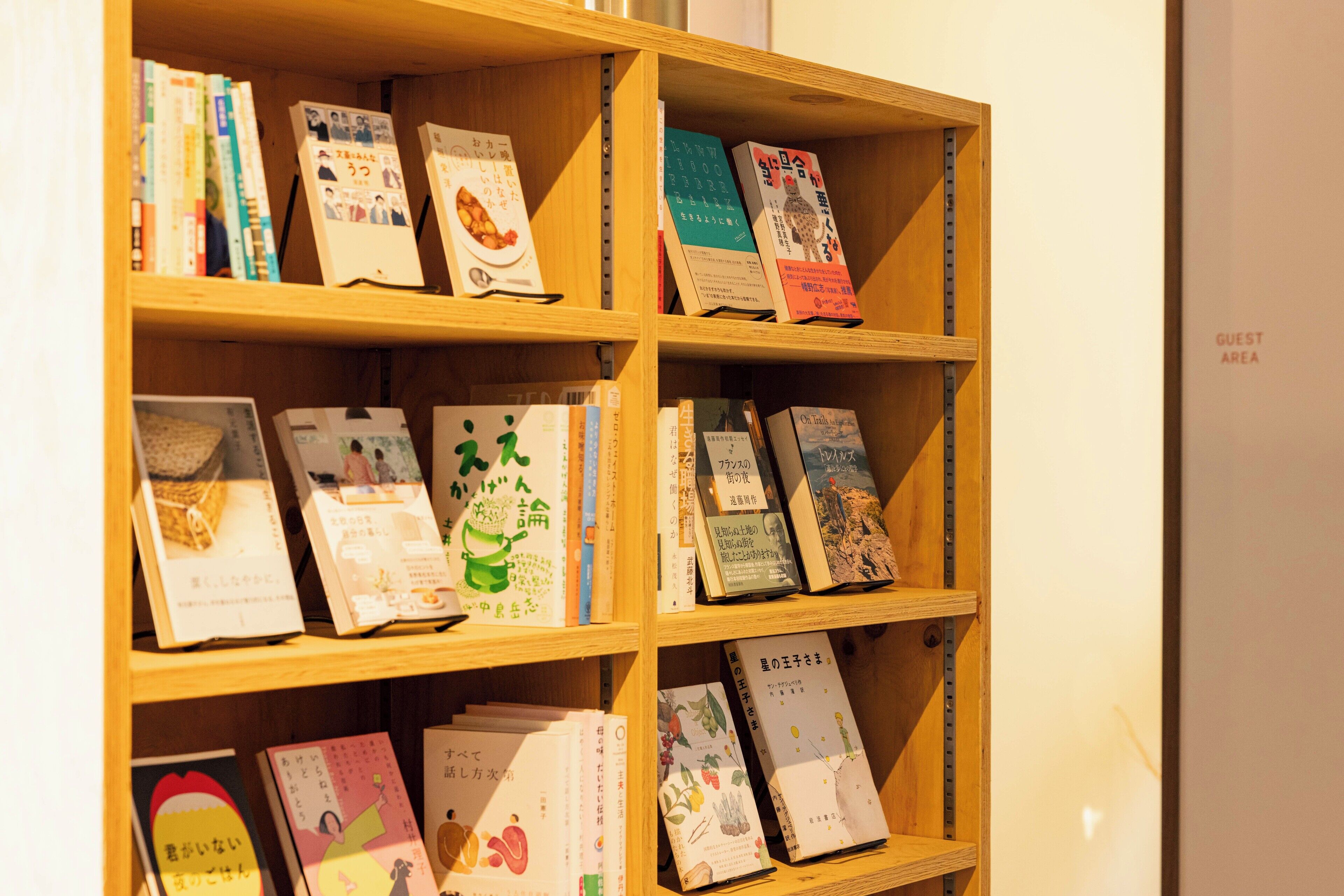 Una estantería de madera con varios libros, algunos con texto en japonés.