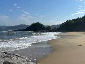 A beach with waves, a sandy shore, and rocky outcrops. - Beach front bliss - Casa Diana (Sayulita)