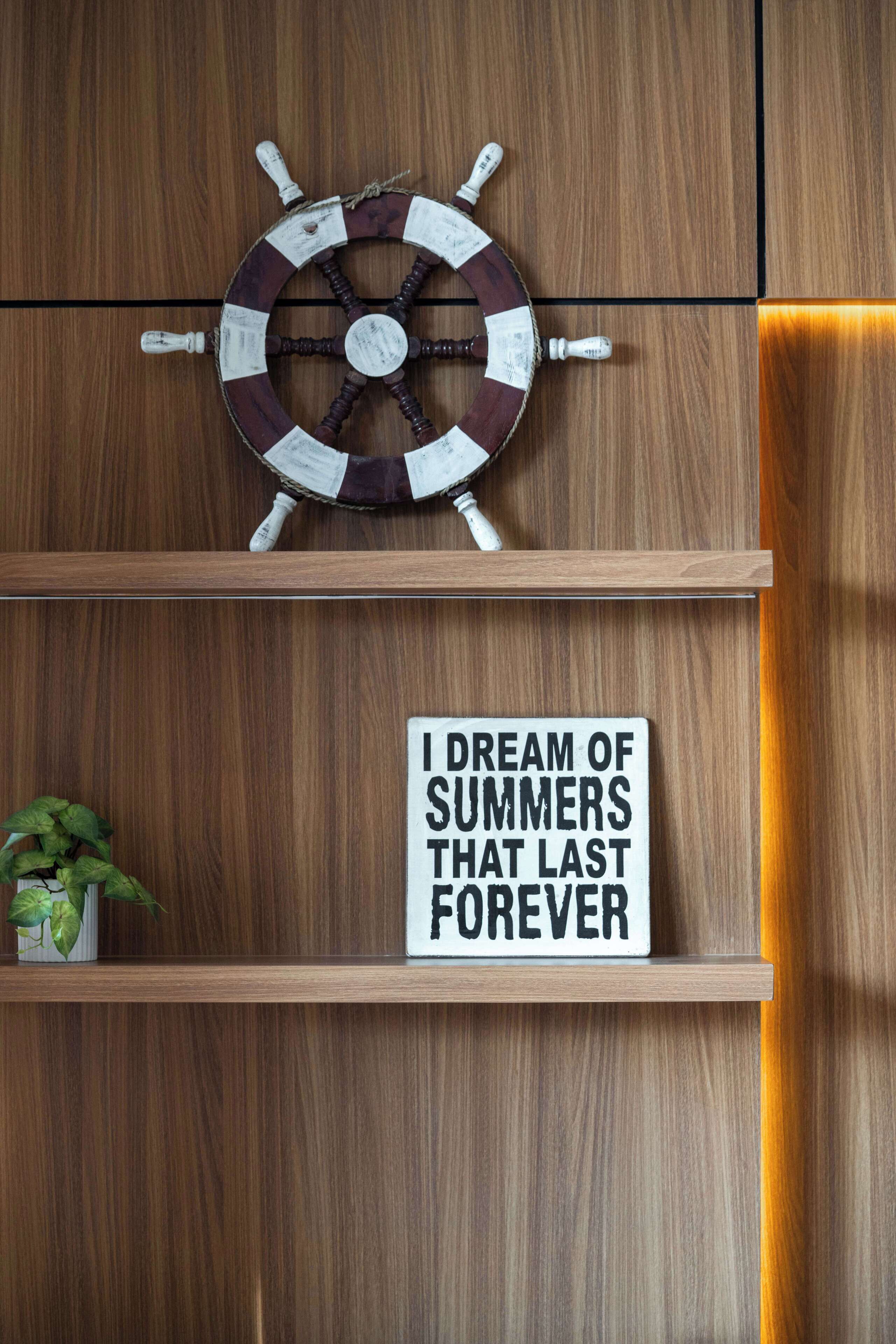 A wooden wall with a ship's wheel and a sign that reads "I DREAM OF SUMMERS THAT LAST FOREVER".