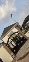 Um edifício com portão preto, detalhes dourados, céu limpo e linhas de energia.