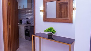 A kitchen with a microwave, oven, and cabinets. - TM Luxe Stays Apartment  (Ibadan)