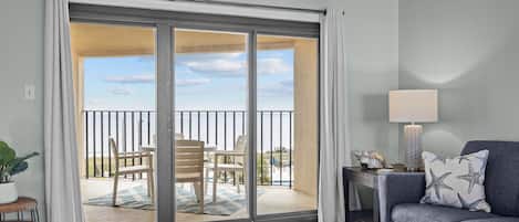 A living room with a sliding glass door leading to a balcony with outdoor furniture.