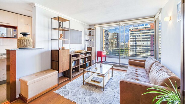 A modern living room with a sofa, coffee table, and bookshelves.