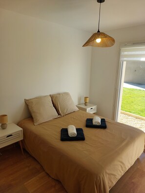 A bedroom with a large bed, bedside tables, a lamp, and a view of the outdoors. - New house 15 minutes from Mont Saint Michel on the GR 34 (Roz-sur-Couesnon)