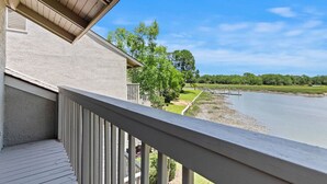 A balcony with a view of a lake and surrounding greenery. - Waterfront Sea Pines Villa | 3 Private Suites, Balconies, Dock Access (Hilton Head Island)