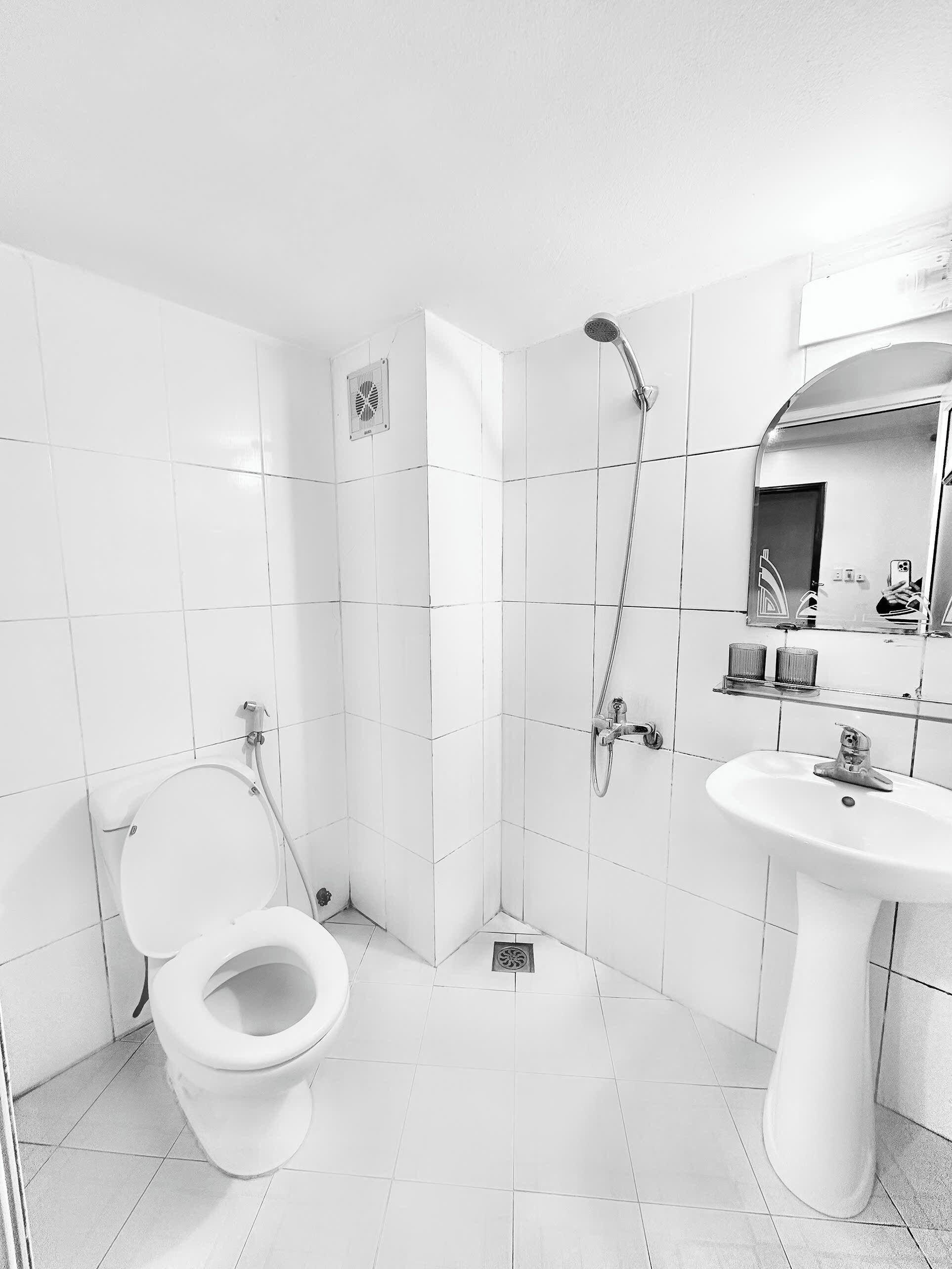A modern bathroom with a toilet, shower, and sink.