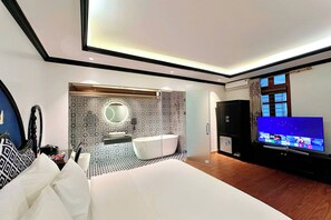 A modern hotel room with a large bed, a bathroom with a bathtub, a TV, and a large window. - Hoang Gia Hotel Cau Giay (Hanoi)