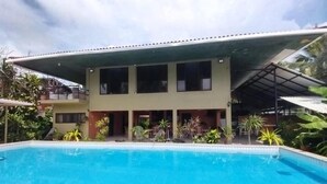 Un edificio de dos pisos con una piscina delantera.