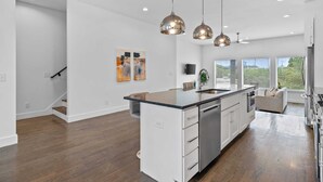 A spacious kitchen with a central island, pendant lighting, and a view to the outdoors.