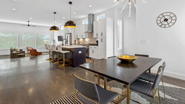 A modern kitchen with white cabinets, a central island, and pendant lighting.