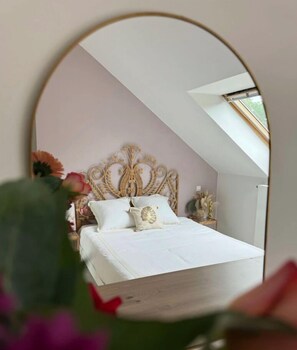 A bedroom with a white bed, ornate headboard, and a skylight. - La Résidence Belle Créole (Quincy-Voisins)