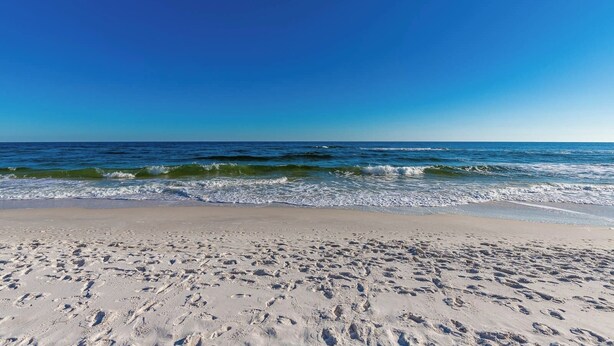 A beach with footprints in the sand and waves approaching the shore. - Grand Caribbean 206 Fun in the Sun! (Orange Beach)