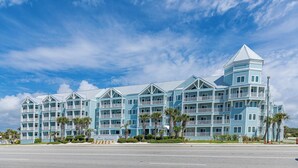 A multi-story hotel with a symmetrical facade, balconies, and a central tower. - Grand Caribbean 206 Fun in the Sun! (Orange Beach)