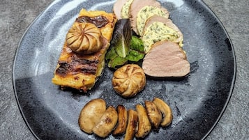 A plate with various food items including roasted potatoes, a piece of meat, and a baked item.