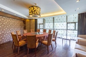 A conference room with a round table, chairs, and a modern chandelier. - Xinhua Hotel Fairy Mountain (Chongqing)