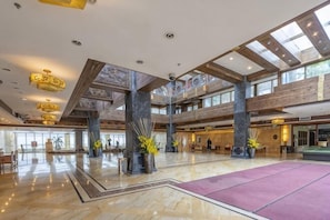 En rymlig entréhall med högt i tak, stora fönster och en central innergård.
