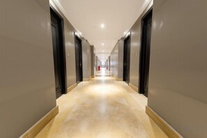Un largo pasillo estrecho con puertas a ambos lados que conducen a habitaciones.