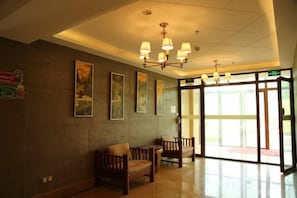 A hotel lobby with a reception desk, seating area, and large windows. - Xinhua Hotel Fairy Mountain (Chongqing)