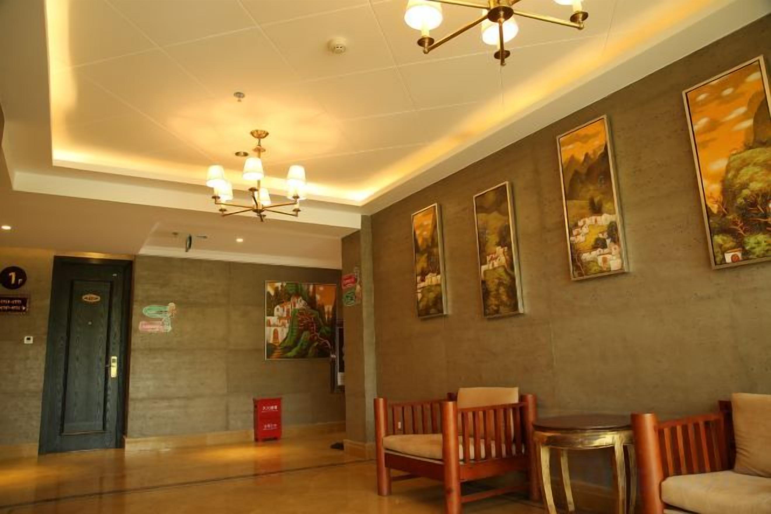 A lobby with a reception desk, seating area, and artwork on the walls.