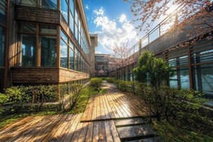 Um edifício moderno com amplas janelas e um deck de madeira.