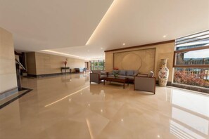 A spacious lobby with a reception desk, seating area, and large windows offering a view. - Xinhua Hotel Fairy Mountain (Chongqing)