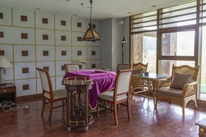 Un comedor con mesa y sillas, una lámpara y vistas amplias a través de grandes ventanales.
