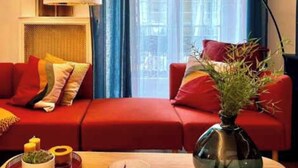 A cozy living room with a red sofa, a round wooden coffee table, and a floor lamp. - Elegant Apartement - AC 2br-6p- Palais des Congres (Paris)