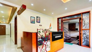 A reception desk with a sign reading "TOWNHOUSE Company Serviced" and a staircase leading to an upper level. - Stylish Stays at MG Road Near Commercial Street (Bengaluru)