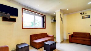 A living room with two sofas, a coffee table, and a TV mounted on the wall. - Stylish Stays at MG Road Near Commercial Street (Bengaluru)