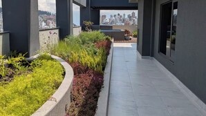 A modern building with a covered walkway and a landscaped garden area.