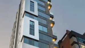 A modern high-rise building with multiple floors, large windows, and a unique facade with patterned elements.