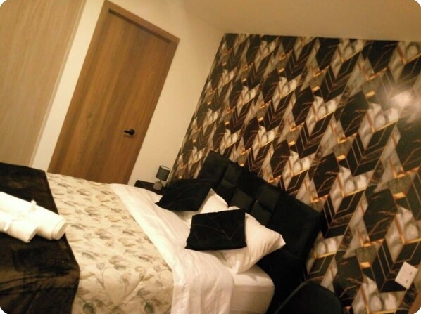 Ein Hotelzimmer mit einem Bett, einer Tür und einer Wand mit Muster.