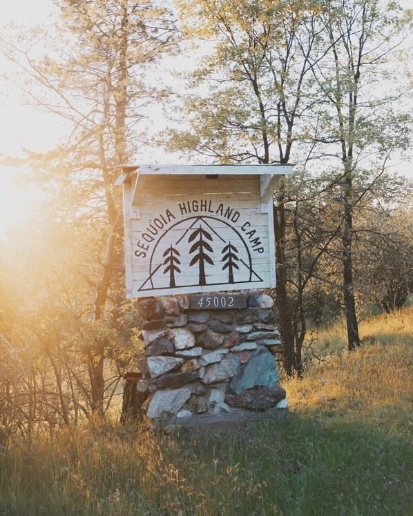 A stone sign with the text "Sequoa Highland Camp" and a number "45002".