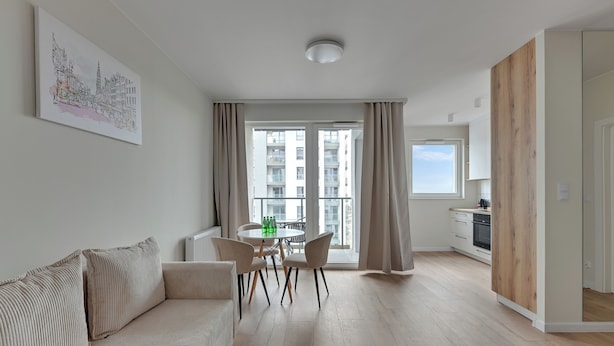 A modern apartment with a living room, dining area, and kitchen.