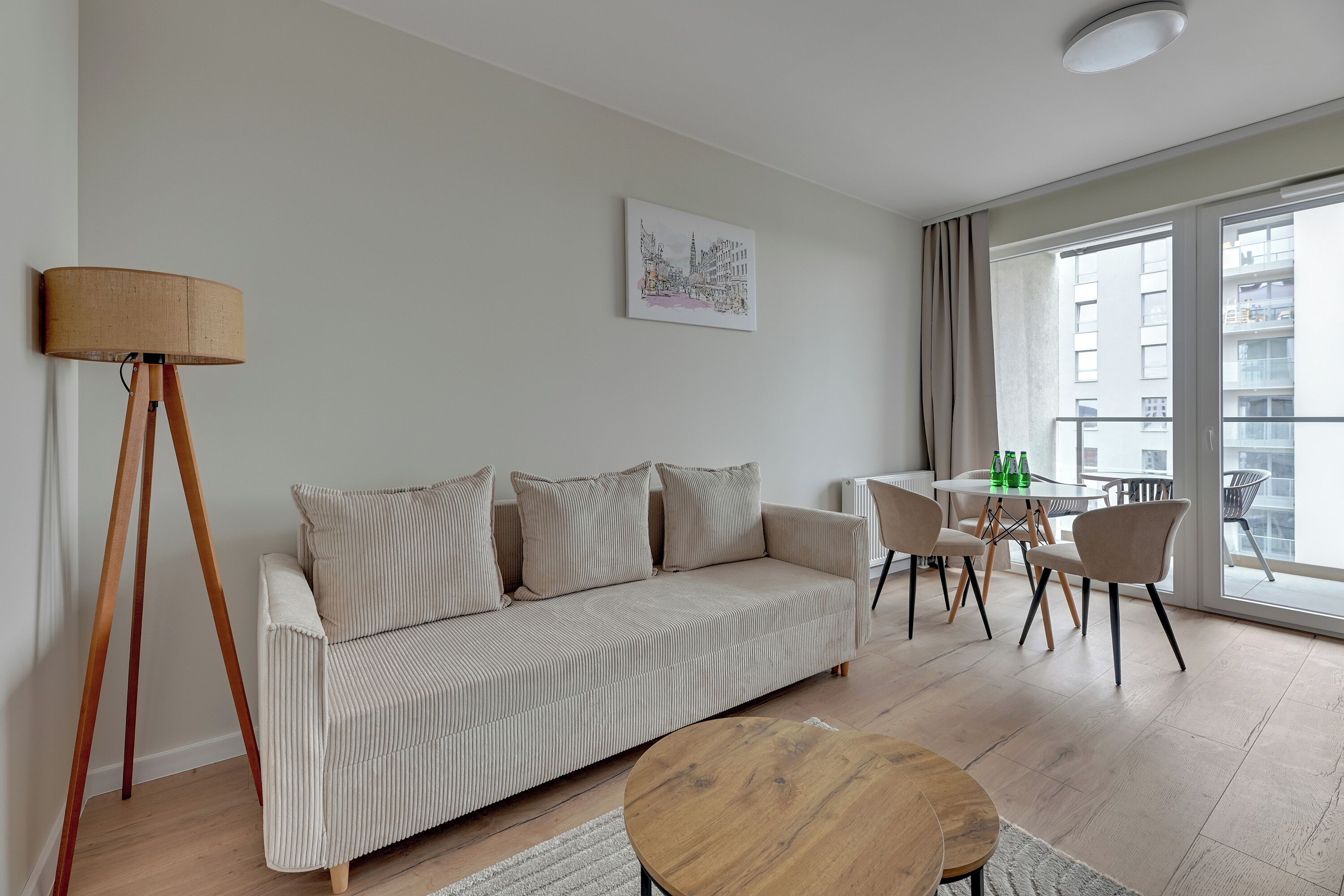 Una sala de estar moderna con un sofá, una mesa de centro, una lámpara de pie y un comedor con sillas y una mesa.