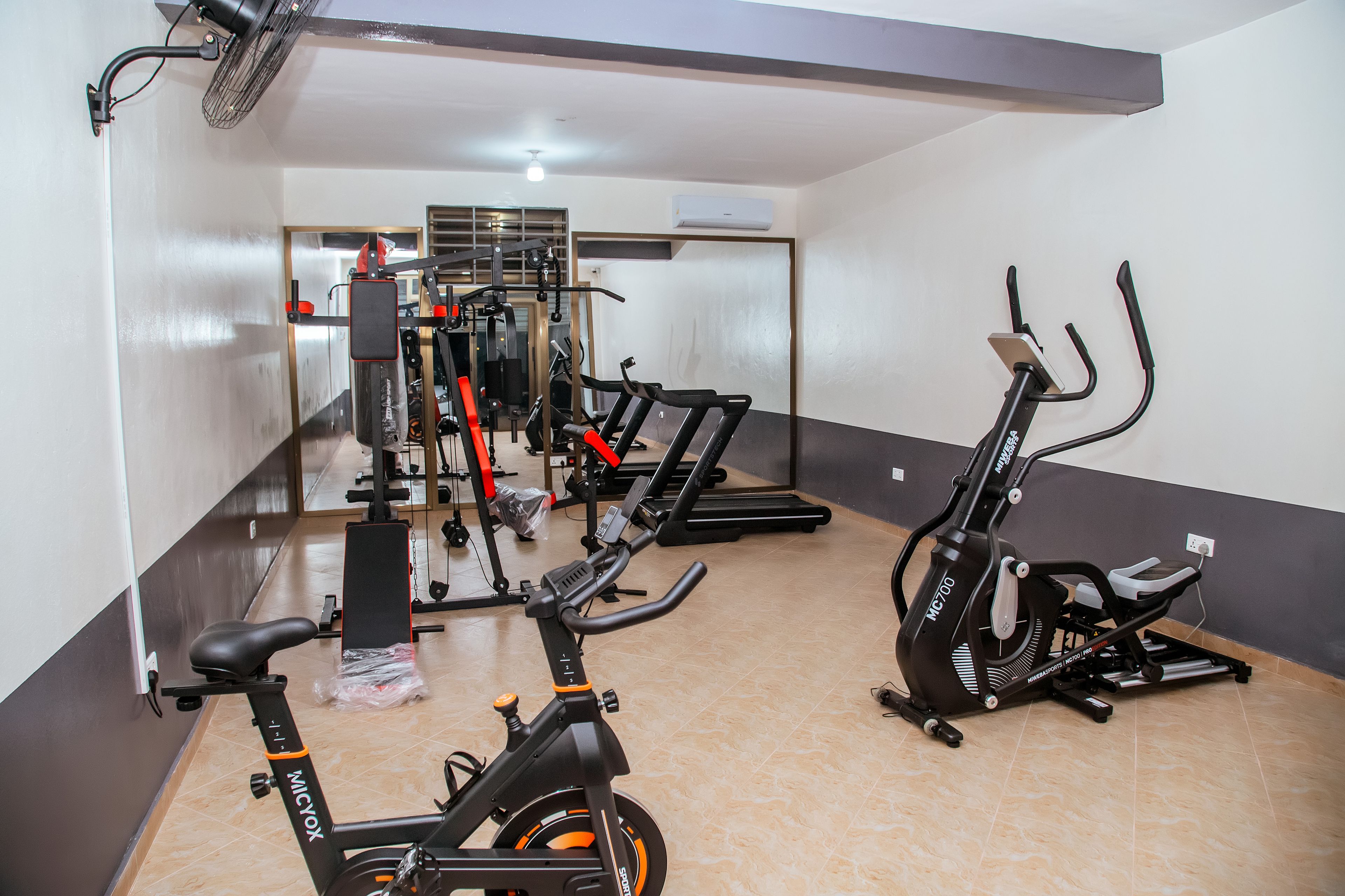 Un gimnasio con bicicletas estáticas, cintas de correr y máquinas de pesas.