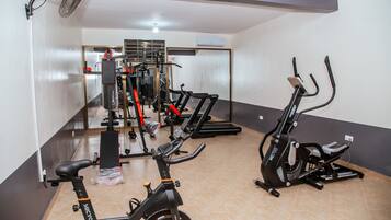 Un gimnasio con bicicletas estáticas, cintas de correr y máquinas de pesas.