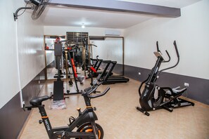 Un gimnasio con bicicletas estáticas, cintas de correr y máquinas de pesas.