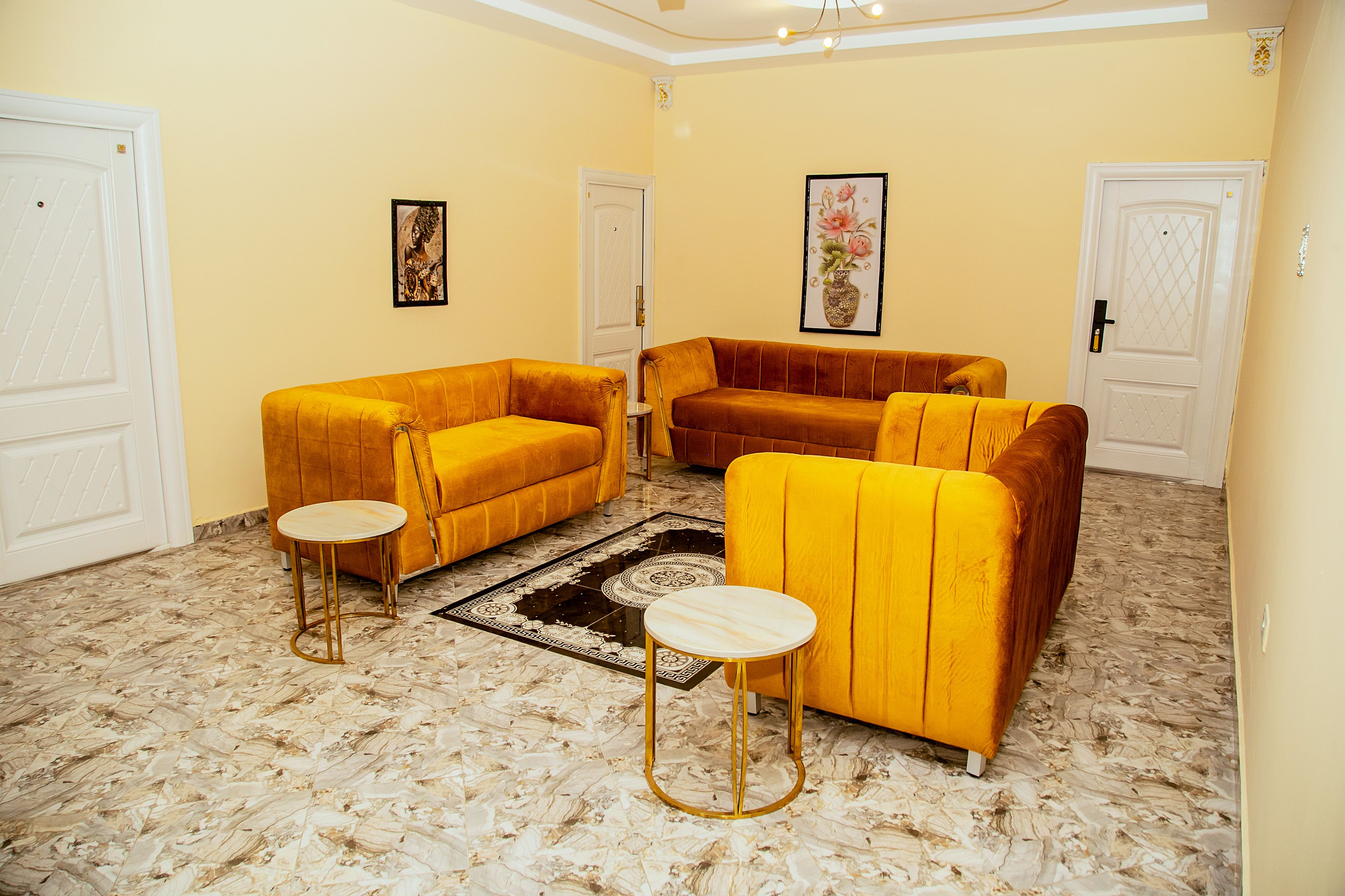 A living room with two yellow sofas, a round coffee table, and a patterned rug.