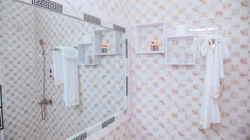 Un baño con un espejo grande, una ducha y dos toalleros.