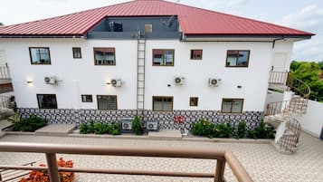 Un bâtiment à deux étages, doté d’un toit rouge, de nombreuses fenêtres et d’un escalier.