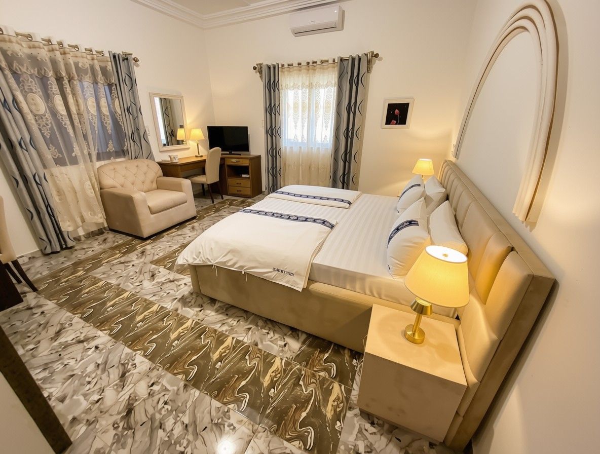 Una habitación de hotel con una cama, una silla, un escritorio, un televisor y una lámpara.