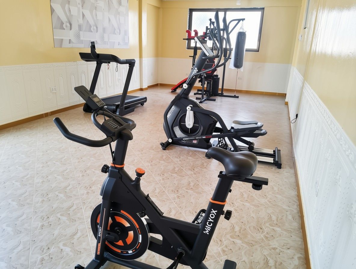 Un gimnasio con bicicletas estáticas, saco de boxeo y equipo de ejercicio.